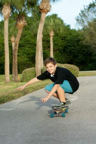 Adolescent boy on a skateboard.