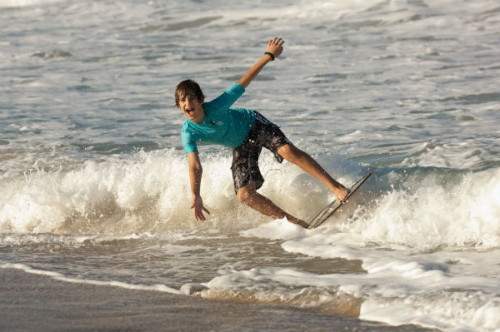 Teenager boogie boarding on the beach