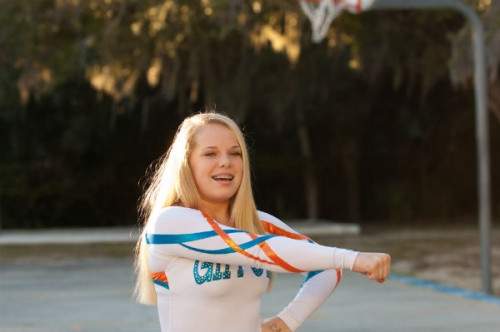Teenage, blonde girl in a cheerleader pose