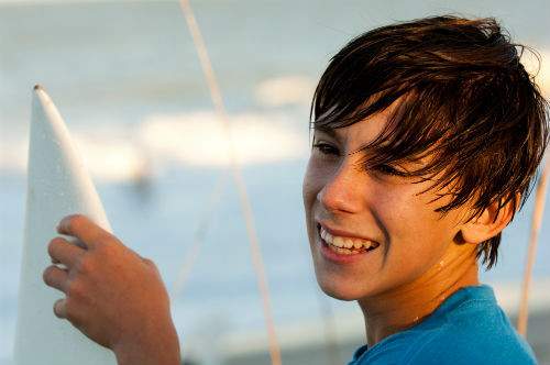 Teen boy smiling and holding a surf board